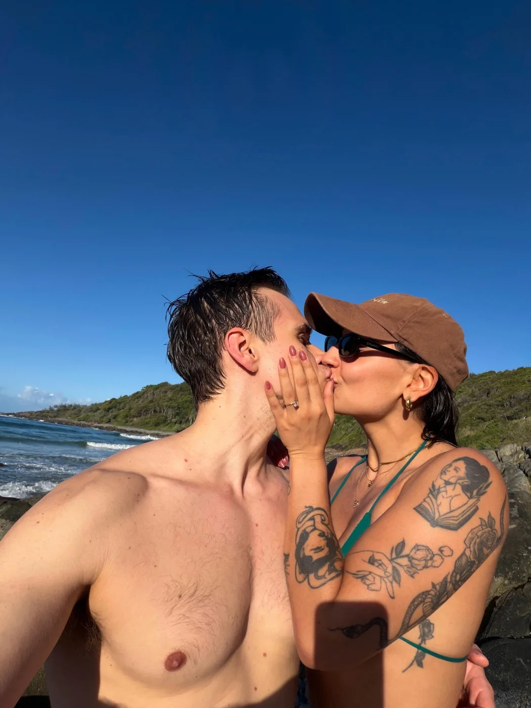 A kiss on the beach, engagement ring on show