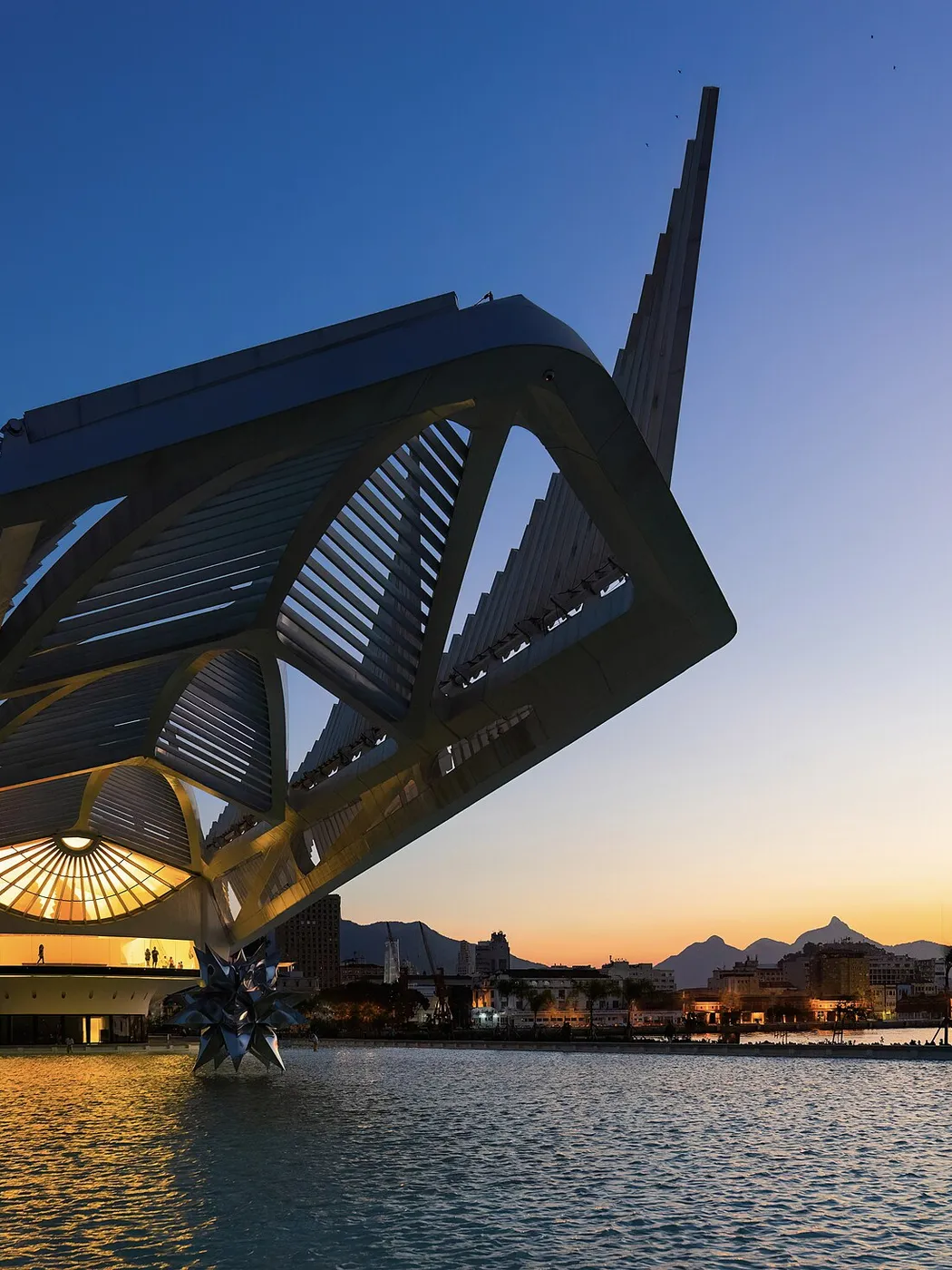 The Museu do Amanh&atilde; at dusk, reflected in its pool